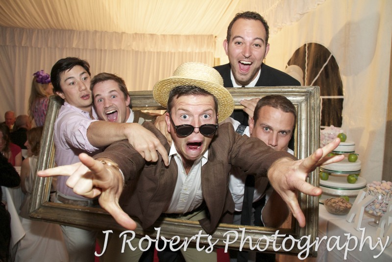 Guests mucking around with a frame at a party - party photography sydney